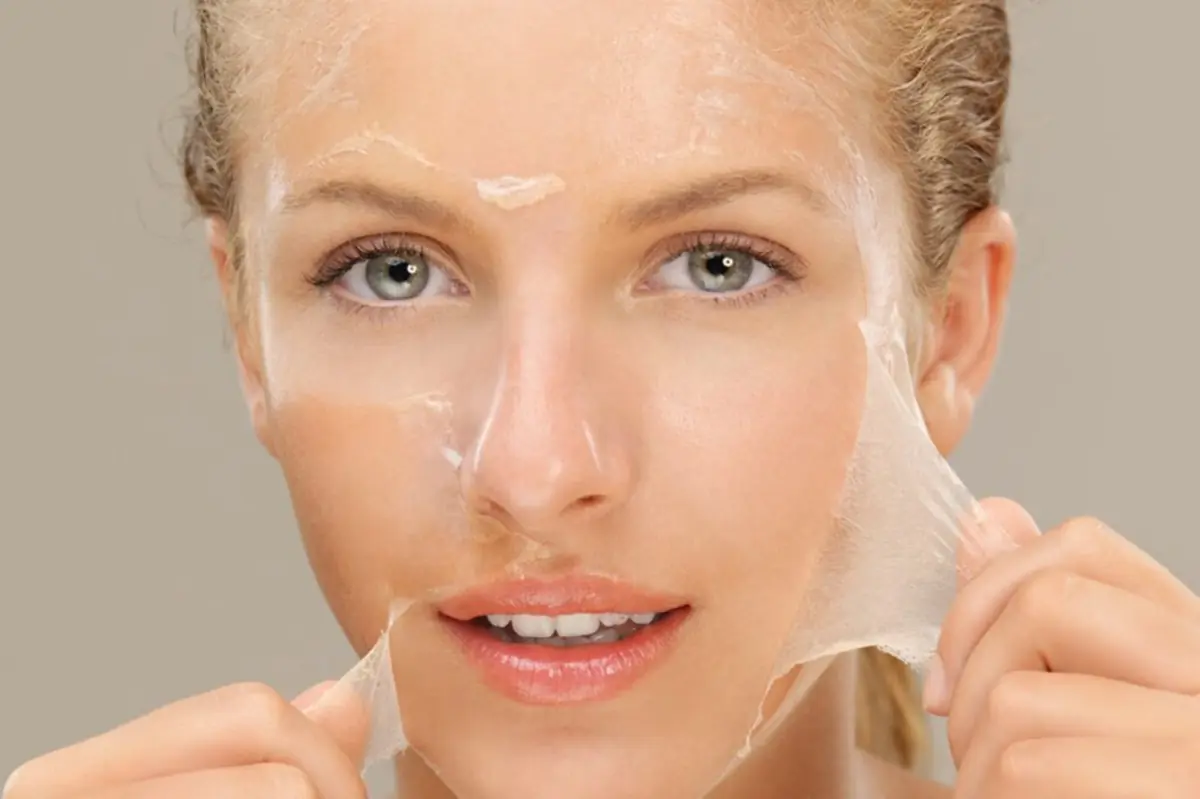 A woman lifting a peel film away from her cheek